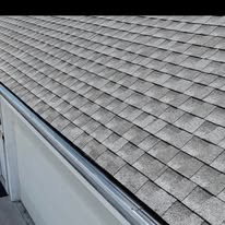 Completed dark gutter along a gray shingle roof by Gutter Haven