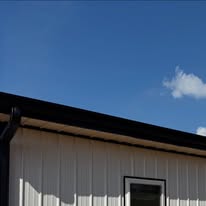 Completed gutters and downspout on a metal building by Gutter Haven